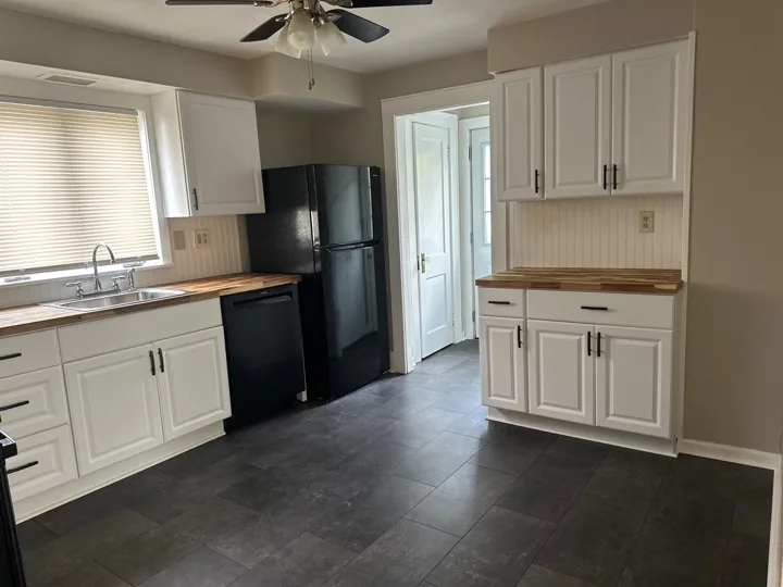 A second view highlights the cabinet storage, countertop space, and light from the window above the sink.
